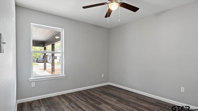 unfurnished room featuring baseboards, dark wood finished floors, and a ceiling fan