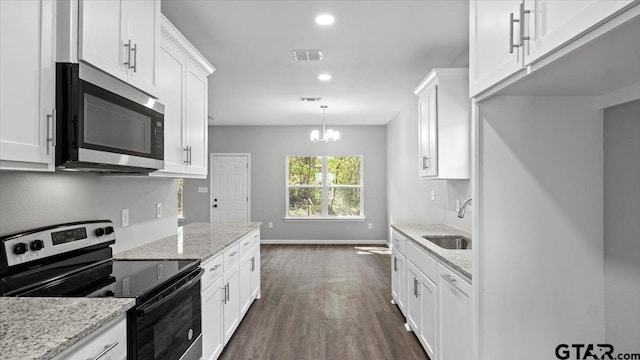 kitchen featuring dark wood-style floors, visible vents, a sink, stainless steel appliances, and white cabinetry