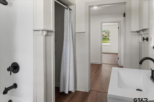 bathroom with hardwood / wood-style flooring, sink, and shower / tub combo with curtain