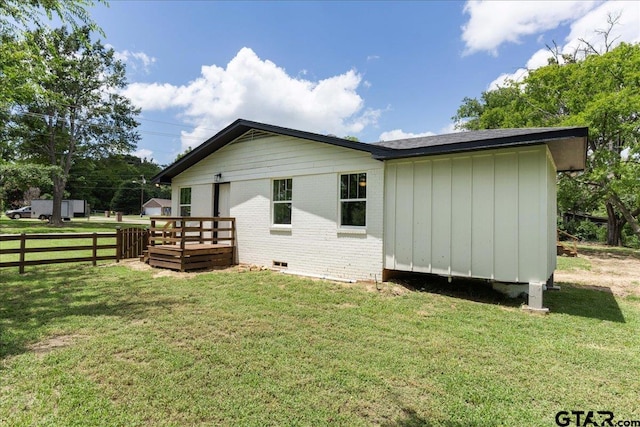 rear view of property with a yard and a deck