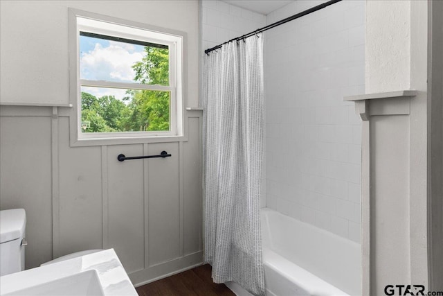 bathroom featuring toilet, hardwood / wood-style floors, and shower / bath combo