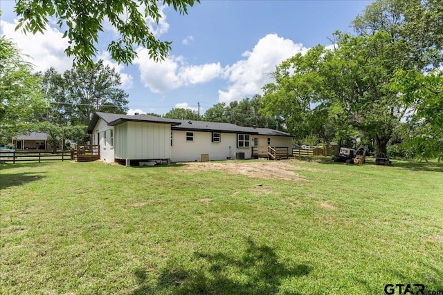 back of house featuring a deck and a lawn