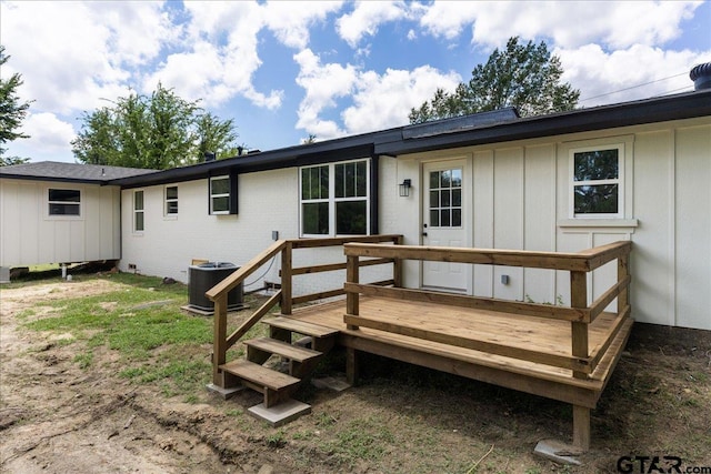 back of property with central AC and a deck