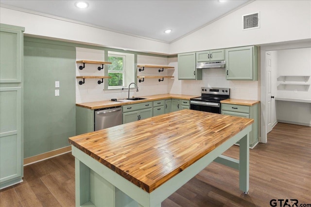 kitchen with vaulted ceiling, appliances with stainless steel finishes, sink, wooden counters, and green cabinets