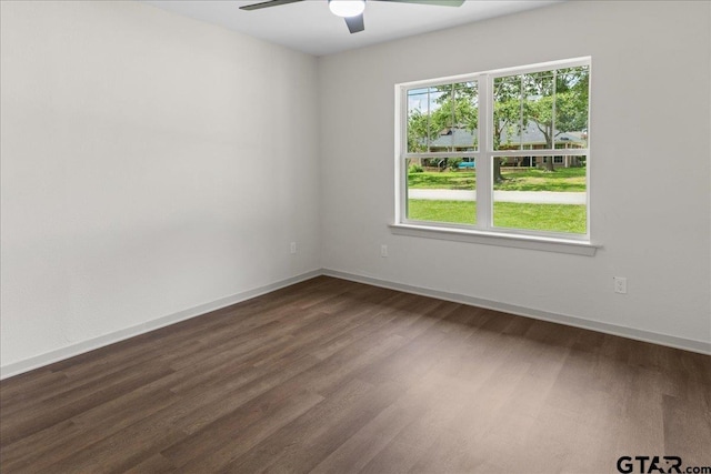 empty room with dark hardwood / wood-style floors and ceiling fan