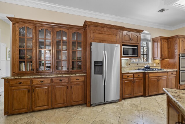 2213 Woodlands Dr, Tyler, TX 75703 - kitchen featuring crown molding, stainless steel appliances, brown cabinets, and visible vents