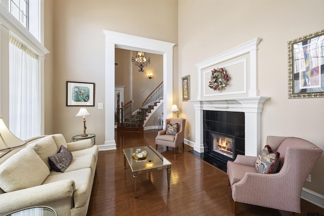 2213 Woodlands Dr, Tyler, TX 75703 - living area featuring a high ceiling, wood-type flooring, a fireplace, a chandelier, and baseboards