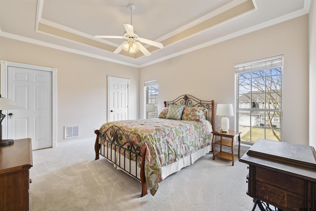 2213 Woodlands Dr, Tyler, TX 75703 - bedroom featuring multiple windows, light carpet, a tray ceiling, and visible vents