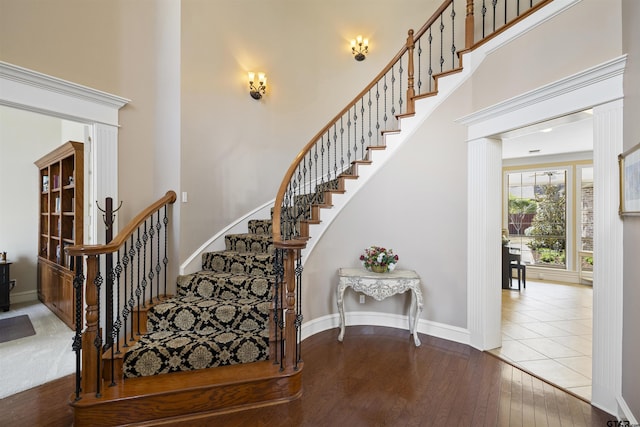 2213 Woodlands Dr, Tyler, TX 75703 - stairs featuring baseboards, a high ceiling, and hardwood / wood-style flooring