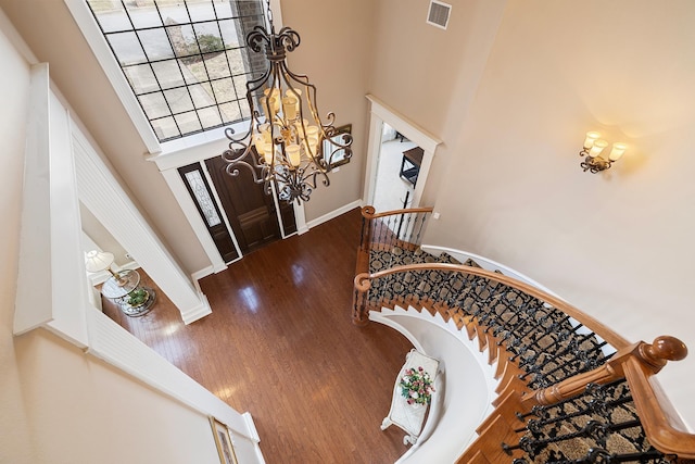 2213 Woodlands Dr, Tyler, TX 75703 - entrance foyer featuring a high ceiling, healthy amount of natural light, a chandelier, wood finished floors, and baseboards