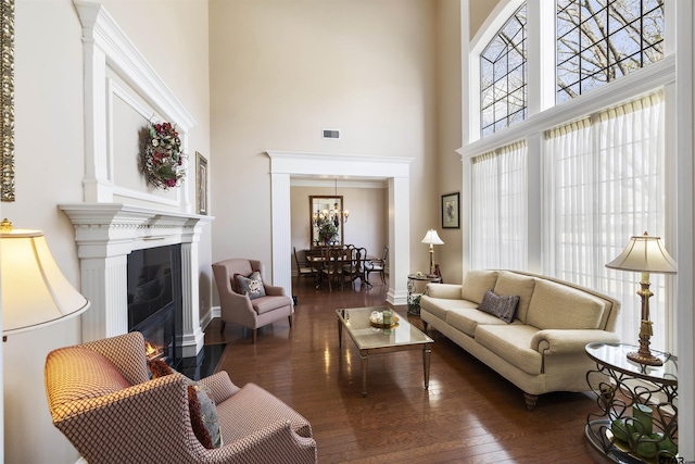 2213 Woodlands Dr, Tyler, TX 75703 - living area with a high ceiling, a fireplace with flush hearth, wood finished floors, and baseboards
