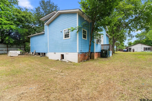 view of home's exterior featuring fence, cooling unit, and a lawn