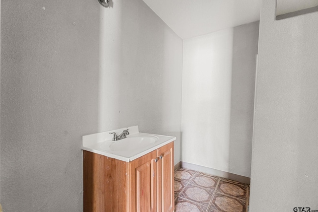bathroom featuring baseboards, tile patterned flooring, and vanity
