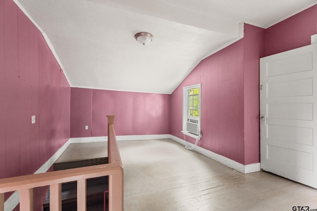 bonus room featuring baseboards, wood finished floors, lofted ceiling, and wooden walls