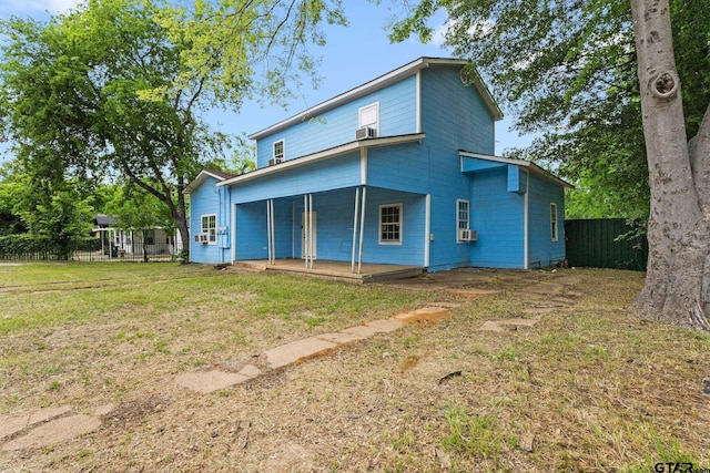 rear view of house with a yard, a porch, fence, and cooling unit