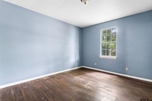 unfurnished room featuring wood-type flooring and baseboards