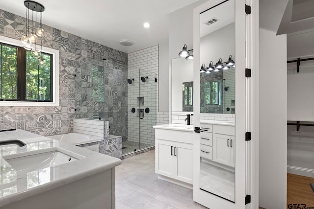 bathroom with tile walls, vanity, and a shower with door