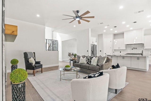 living room featuring light hardwood / wood-style floors and ceiling fan