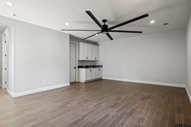 unfurnished living room featuring hardwood / wood-style floors and ceiling fan