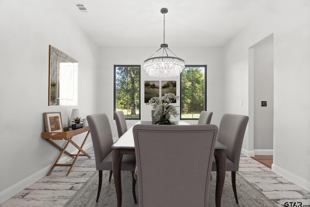 dining area with a chandelier and light hardwood / wood-style flooring