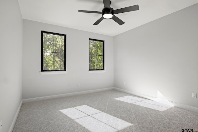 carpeted spare room with ceiling fan