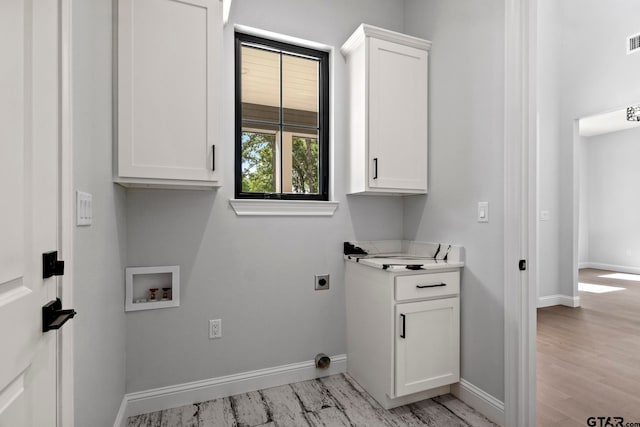 laundry area with hookup for an electric dryer, light hardwood / wood-style floors, washer hookup, and cabinets