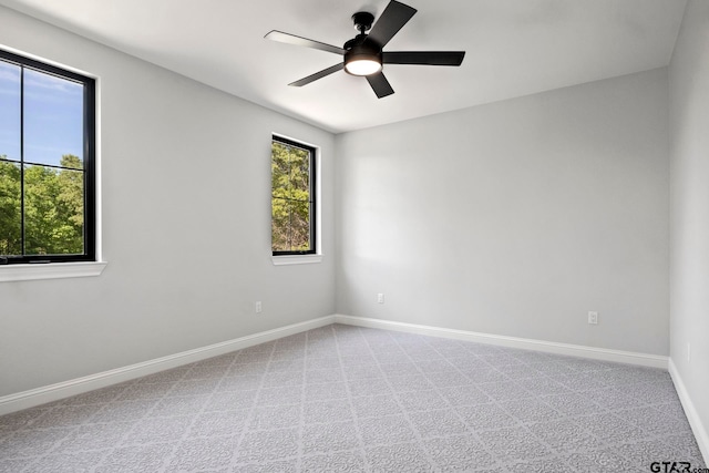 empty room featuring ceiling fan and carpet