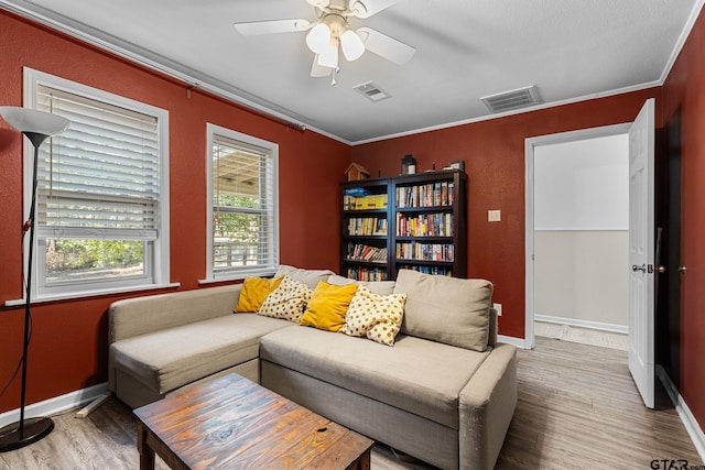 living room with ceiling fan, wood-type flooring, and crown molding