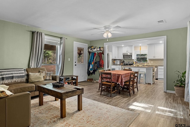 living room featuring ceiling fan and light hardwood / wood-style flooring