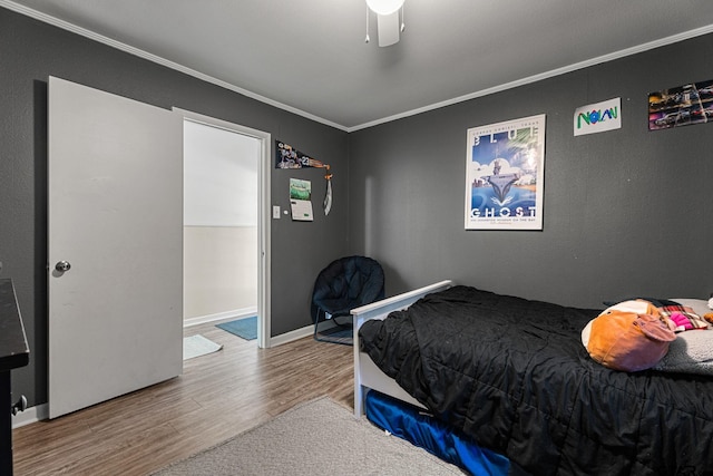 bedroom with hardwood / wood-style flooring, ceiling fan, and crown molding