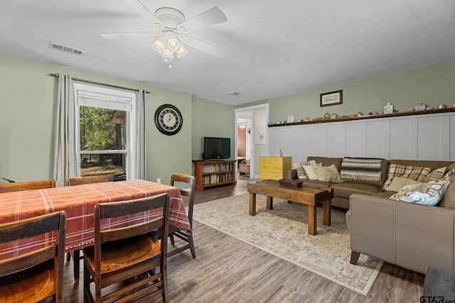 living room featuring wood-type flooring and ceiling fan