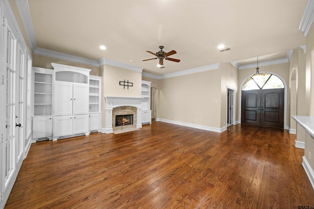 unfurnished living room featuring dark wood-type flooring, ceiling fan, and crown molding