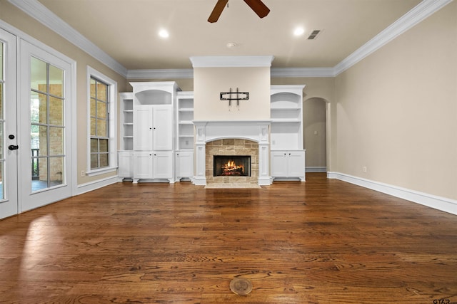 unfurnished living room with ornamental molding, a fireplace, dark wood-type flooring, and ceiling fan