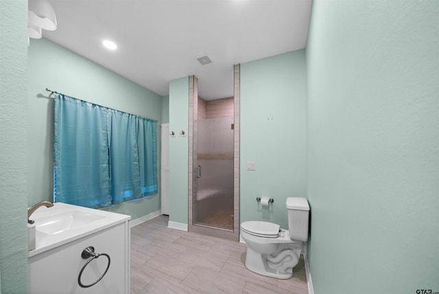 bathroom with an enclosed shower, vanity, and toilet