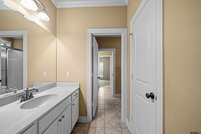 bathroom with ornamental molding, tile patterned flooring, walk in shower, and vanity