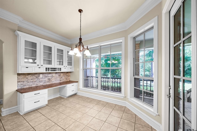 kitchen with butcher block countertops, white cabinetry, pendant lighting, and decorative backsplash