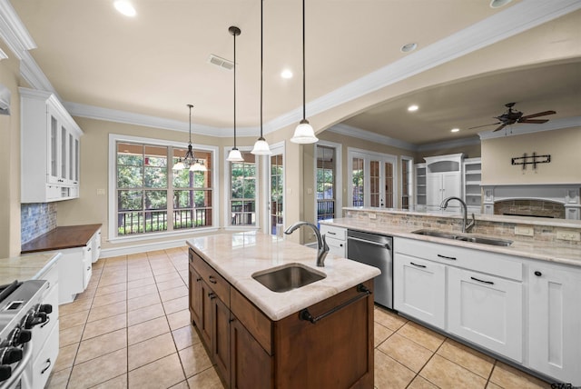 kitchen featuring stainless steel appliances, sink, decorative light fixtures, and an island with sink