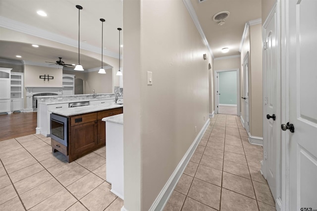 kitchen with stainless steel appliances, crown molding, light tile patterned floors, pendant lighting, and ceiling fan