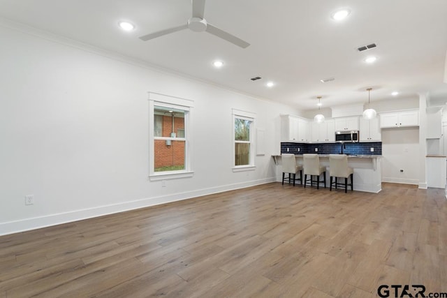 kitchen featuring crown molding, light hardwood / wood-style flooring, and ceiling fan