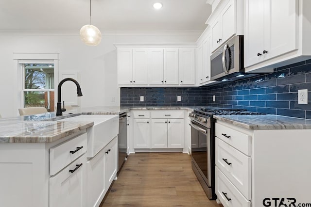 kitchen featuring white cabinetry, ornamental molding, and appliances with stainless steel finishes