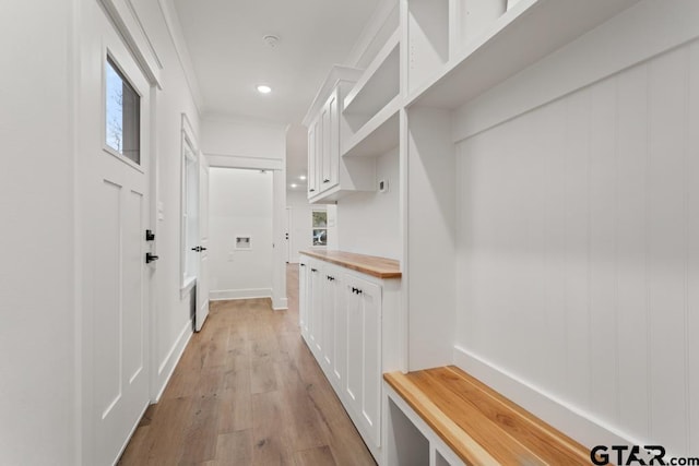 mudroom with crown molding and light hardwood / wood-style floors