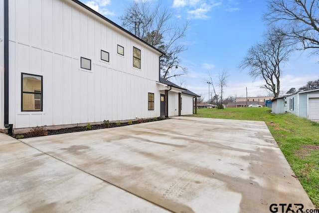 view of side of home with a yard and a patio area