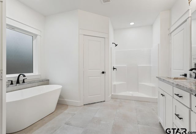 bathroom featuring independent shower and bath, vanity, and tile patterned floors