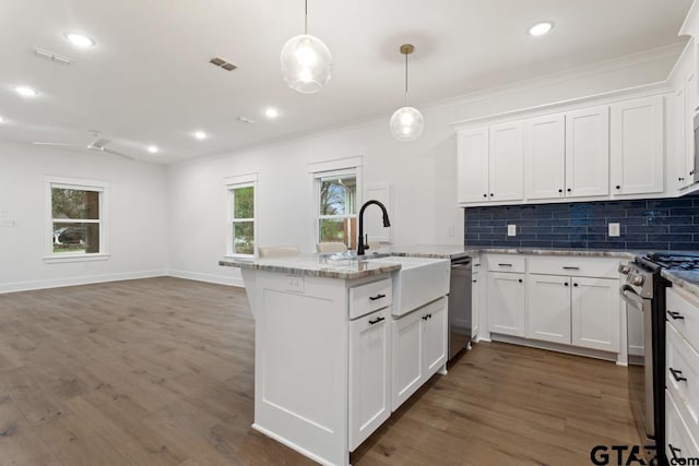 kitchen featuring sink, appliances with stainless steel finishes, hanging light fixtures, tasteful backsplash, and white cabinets