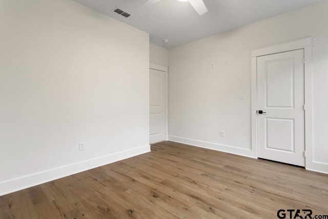 empty room with ceiling fan and light hardwood / wood-style floors