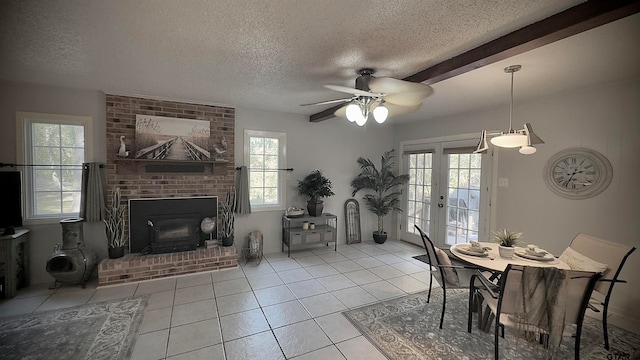 dining space with a fireplace, a textured ceiling, ceiling fan, and beam ceiling