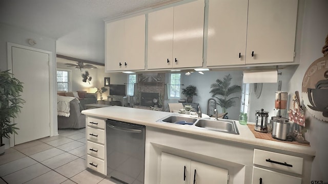 kitchen featuring sink, ceiling fan, light tile patterned floors, a fireplace, and dishwasher