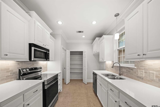 kitchen featuring sink, stainless steel appliances, tasteful backsplash, decorative light fixtures, and white cabinets