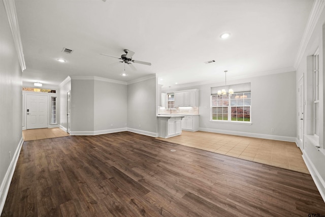 unfurnished living room with hardwood / wood-style floors, ceiling fan with notable chandelier, and crown molding