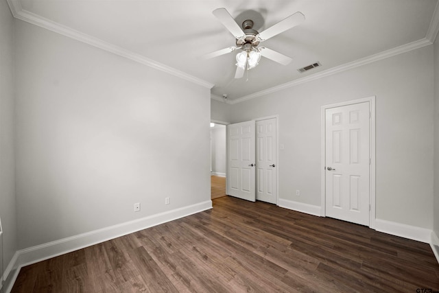 unfurnished bedroom with ceiling fan, dark hardwood / wood-style floors, ornamental molding, and multiple closets